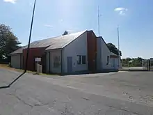 Photographie en couleurs d'un bâtiment récent avec garages partiellement peints en rouge