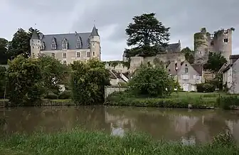 Photographie en couleurs d'une rivière calme au pied d'un château.