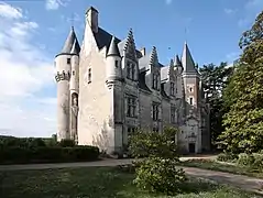 Vue d'un château montrant une échauguette à l'angle de deux murs au premier plan.