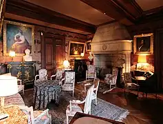 Photographie en couleurs d'une pièce de château, richement meublée et décorée.
