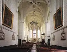 Photographie en couleurs de l'intérieur d'un édifice religieux, vu dans l'axe de sa nef.