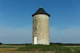 Photographie en couleurs d'un moulin-tour dépourvu de ses ailes.