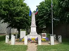 Monument aux morts de Chartainvilliers, présentant, sur la gauche, une stèle ainsi rédigée : « A la mémoire des officiers et soldats du 26e Régiment de Tirailleurs Sénégalais tombés sur le territoire de la commune en juin 1940. Ils sont 56 ! »