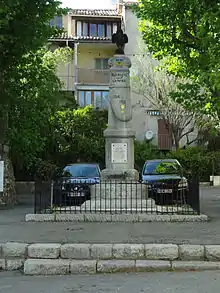 Le monument porte un coq fier, la mention "Aux morts pour la patrie" et la médaille de guerre en couleurs.