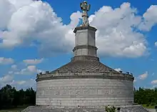 Monument ressemblant à un mausolée surmonté par une gigantesque statue, construction moderne.