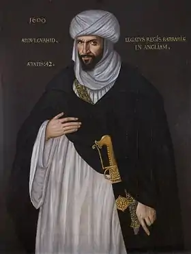 Portrait d'un homme barbu portant une djellaba et un turban blanc avec une tunique noire