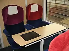 Vue d'un espace de seconde classe : deux sièges et une tablette.