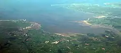 Panorama de la quasi-totalité de la baie de Morecambe allant de l'est (bas de la photo) à l'ouest (haut de la photo). Barrow-in-Furness et Walney Island peuvent être aperçus dans la partie supérieure de la photo et Lancaster ainsi que Morecambe sont visibles dans le coin inférieur gauche de la photo.