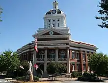 Photo d'un grand bâtiment avec une horloge et un drapeau des États-Unis.