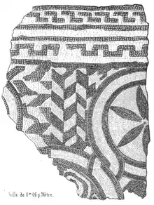Fragment de pavé en mosaïque avec trois motifs en forme de fleurs.
