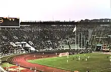 Photographie d'un stade de football, vu de haut. On voit les tribunes à gauche et la pelouse à droite.