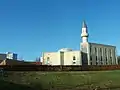 photo d'une mosquée surmontée d'un minaret sur fond de ciel bleu.