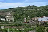 Photographie de collines dans lesquelles s'insère un bâtiment monastique.