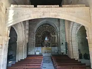 Photographie d'un intérieur d'église ancienne, avec un arc surbaissé à mi-hauteur
