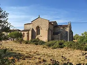 Photographie d'une petite église de style roman dans une végétation méditerranéenne.