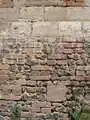 Détail de mur d'étable :soubassement en briques eten silex disposés en escalier.