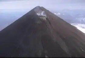 Vue aérienne du mont Pavlof montrant son cratère sommital fumant.