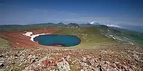 Vue du lac de cratère de l'Ajdahak avec d'autres sommets volcaniques du massif de Gegham en arrière-plan.