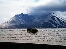 Photographie couleur d'un détail d'un mémorial avec le nom de Truman inscrit et la montagne en arrière-plan.