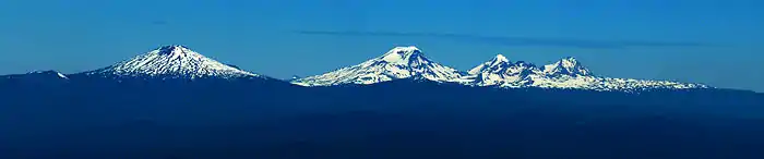 Vue panoramique de quatre montagnes enneigées.