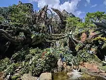 Cascade qui coule au milieu d'arbre et de petits arbustes.