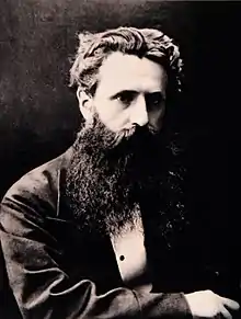 Photographie ancienne en buste d'un homme à la barbe et aux cheveux noirs.