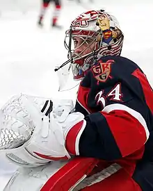 photographie d'un gardien de but de hockey sur glace avec un maillot rouge