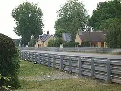 Maisons du lieu-dit et glissières de sécurité du circuit.