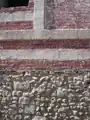 Détail de mur de ferme :blocs de craie et briques sur solin en silex épannelés.