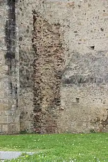 Vue de murs d'un bâtiment et au centre un mur plus ancien.