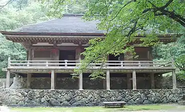 Wooden building. In front of the entrance there is an open veranda constructed on poles.