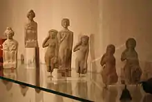Photographie d'une groupe de statuettes féminines en exposition dans un musée.