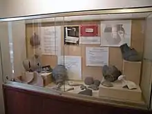 Photographie de poteries antiques exposées derrière une vitrine.