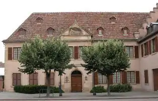 Photographie couleur d'un bâtiment de style classique, en pierres de taille, avec un fronton.
