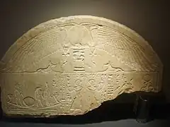 Exemple de lunette avec ailes, (remplissant le demi-cercle en haut de la stèle)