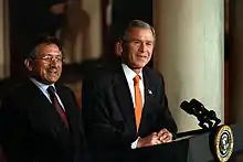 Deux hommes devant un pupitre arborant le sceau présidentiel américain