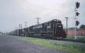 1988. Une GE C36-7 encore en livrée Norfolk & Western, remorque un train d'automobiles avec une EMD SD60 NS.