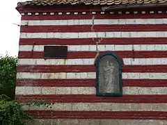 Oratoire-niche dans un mur de ferme.