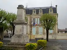 A l'arrière plan, la Mairie et au premier plan le monument aux Morts situé Place de la Mairie.