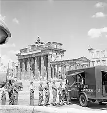 Photographie de soldats faisant la file devant une camionnette-cantine près de la porte de Brandebourg