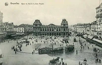La place au début du XXe siècle, avec l'ancienne gare du Nord et les tramways.
