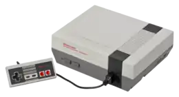 Console de jeu vidéo grise, avec une manette connectée.