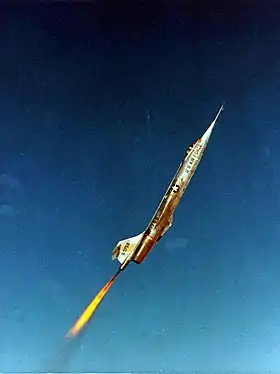 Photographie couleur d'un avion à réaction propulsé par un moteur fusée supplémentaire.