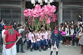 Enfants tenant des fleurs géantes en papier.