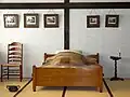 Chambre avec tatamis et lit et pot de chambre occidentaux.