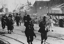 Survivants du bombardement atomique traversant Nagasaki