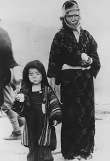 Enfant et sa mère mangeant des onigiri. 10 août 1945, lendemain des bombardements atomiques, à Nagasaki Ichiguchi-cho (à 1,5 km de l'hypocentre)