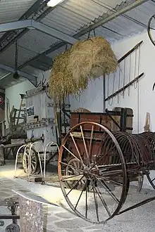 Râteau andaineur pour cheval, presses à foin manuelles et bottes sommairement liées. Années 1900