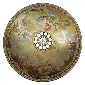 Vue du dessous, une peinture circulaire, avec des personnage de style antique. Au centre, le lustre allumé.