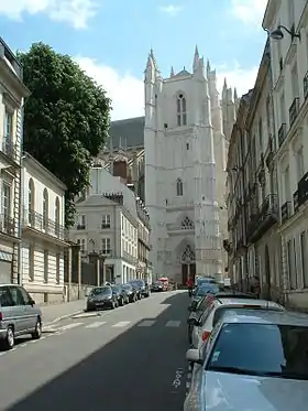 Photo de la rue du Roi-Albert, à Nantes ; elle est longée de bâtiments du XIXe siècle rectilignes et blancs, on voit au fond se dresser la cathédrale de Nantes